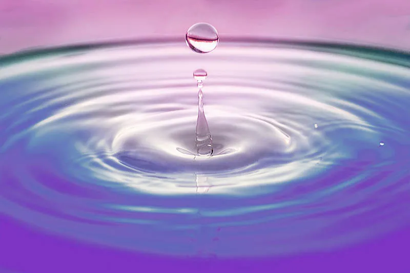 a drop falling into the water creating ripples on the surface as a metaphor for energy vibrations going out