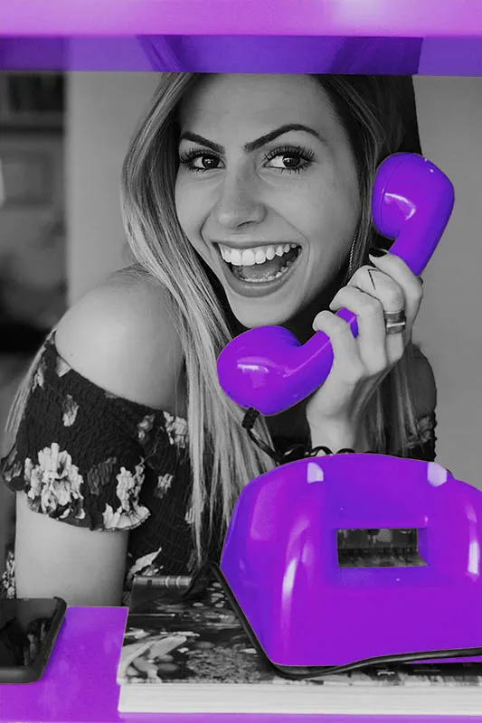 happy and high vibrational woman holding a colourful telephone feeling comfortable in her own skin