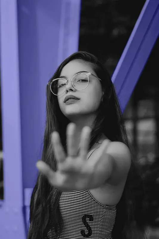 Woman setting a boundary by putting up her hand in front of the camera