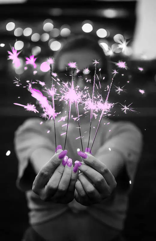 Woman holding sparklers, celebrating successes brings your more abundance over time