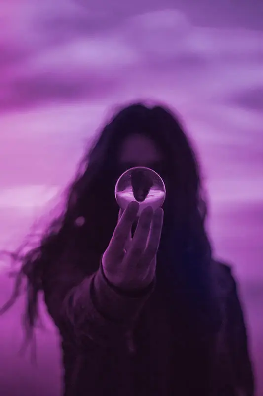 Woman holding a glass ball, as a symbol of clarity coming through practicing spirituality