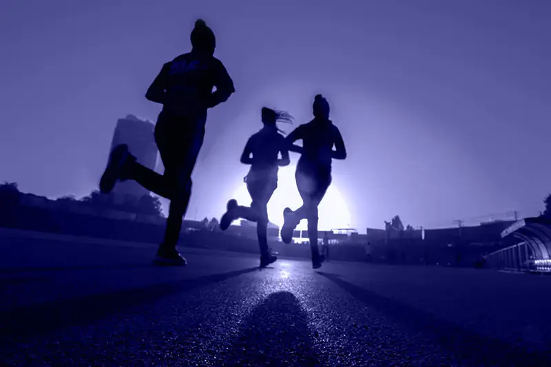 silhouettes of women running in the evening sun. Working out and enjoying it raises your vibration