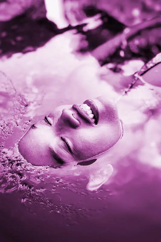 spiritual woman looking peaceful floating with her head in the water