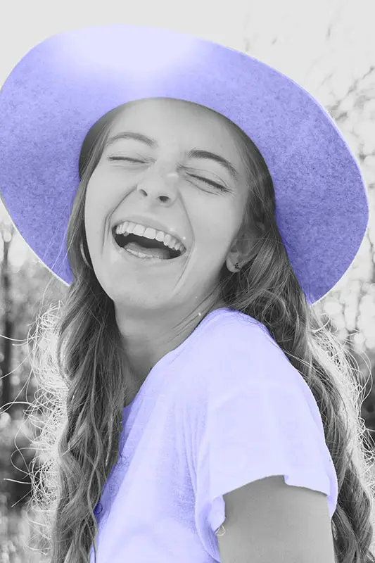 Happy smiling woman wearing a summer hat, with a lens flair 